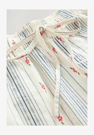 Ziedu raksta kokvilnas topiņš ar zilām svītrām, sapulcinātu kakla izgriezumu un priekšpusē sasienamu detaļu.