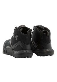 Scarpe sportive nere con una tomaia in rete testurizzata, colletto imbottito e suola in gomma con battistrada robusto per una buona aderenza. I dettagli includono un logo.