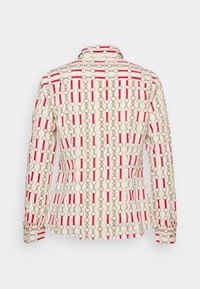 Camicia colletto color crema con motivo di anelli dorati e barre rosse. Design aderente con maniche lunghe e polsini con bottoni.