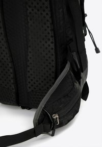 Sac à dos noir avec des panneaux en maille texturée et un motif hexagonal. Comprend des accents gris, une poche zippée et des bretelles réglables.