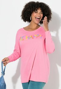 Vaaleanpunainen pitkähihaiseksi T-paita, jossa on "BE HAPPY" monivärisellä, sawtooth-ompelulla. Pehmeä, kevyt kangas, rento istuvuus. Yhdistettynä sinisiin asusteisiin.