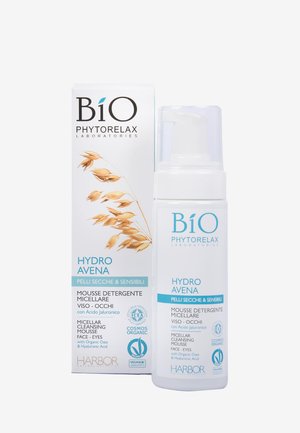 Mousse nettoyante micellaire dans une bouteille blanche avec une pompe, étiquetée "Hydro Avena" et décorée d'illustrations d'avoine sur une boîte.