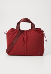 Borsa di stoffa rossa con una texture stropicciata, dotata di manici corti e di una tracolla regolabile più lunga. Chiusura con cordoncino di rilievo e accenti laterali.
