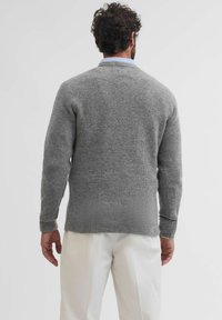 Maglione grigio lavorato a maglia con maniche lunghe e orlo arrotondato, caratterizzato da una finitura testurizzata. Il retro è semplice, mettendo in risalto il motivo a maglia.