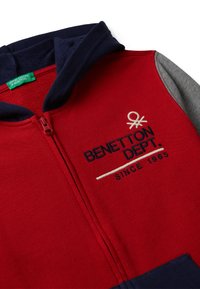 Felpa rossa con zip, caratterizzata da accenti blu navy e grigi, tessuto testurizzato, logo ricamato e colletto alto. Realizzata in morbido cotone.