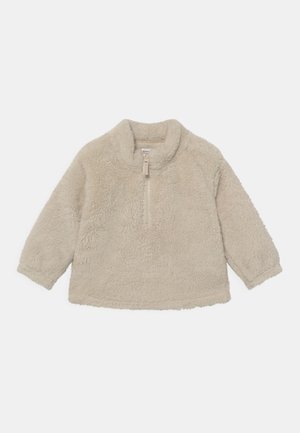 Beige fleece-pullover med lange ærmer, ståkrave og halv lynlås foran i midten.