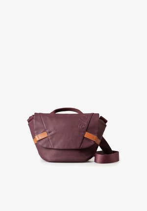 Maroon leather bag with a fold-over flap, brown leather accent straps, short handle, and long adjustable strap; smooth texture and minimalist design.