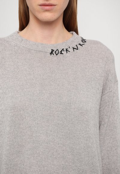 Svijetlosivi pulover izrađen od meke pletene tkanine, s okruglim izrezom i crnim izvezenim tekstom "ROCK'N" blizu ovratnika. Udoban kroj.