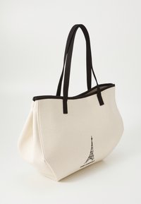 Borsa tote in tela color crema, con accenti neri e due manici. Include un'illustrazione della Torre Eiffel su un lato.
