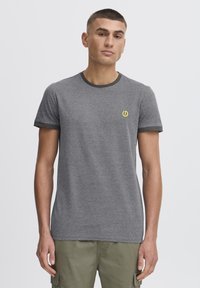 Grå bomulds T-shirt med korte ærmer, kontrasterende mørkegrøn ringer-udskæring og et lille gult logo på brystet. Glat tekstur.