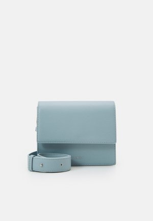 Sac bandoulière rectangulaire bleu clair avec une longue sangle ajustable enroulée à côté sur fond blanc.