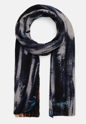 Donkerblauwe en grijze geribbelde sjaal met abstract patroon, opgevouwen in een lus met hangende uiteinden, voorzien van kleine kleurrijke accenten en de tekst "Desigual".