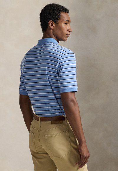 Μπλε ριγέ πόλο μπλούζα με κοντά μανίκια και ριμπ γιακά, συνδυασμένη με χακί παντελόνι με ζώνη και τσέπες στο πίσω μέρος.