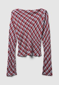 Top a maniche lunghe con spalle scoperte, con un motivo a quadri diagonali in rosso, bianco e nero, esposto in piano su uno sfondo chiaro.
