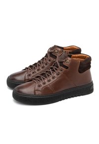 Brązowe skórzane buty typu high-top z zamszowym kołnierzem w okolicy kostki, okrągłym noskiem i teksturowaną czarną gumową podeszwą. Posiadają metalowe otwory na sznurówki i sznurówki.