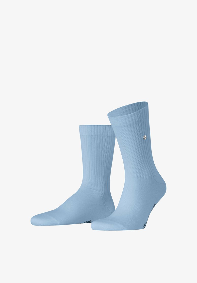 Paire de chaussettes basses bleu clair à texture côtelée avec un petit logo rond sur le dessus, isolées sur fond blanc.