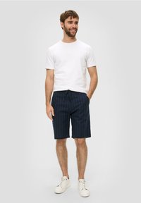 Marine gestreepte short met een elastische tailleband, gecombineerd met een eenvoudig wit T-shirt en witte sneakers. Casual fit en lichtgewicht stof.