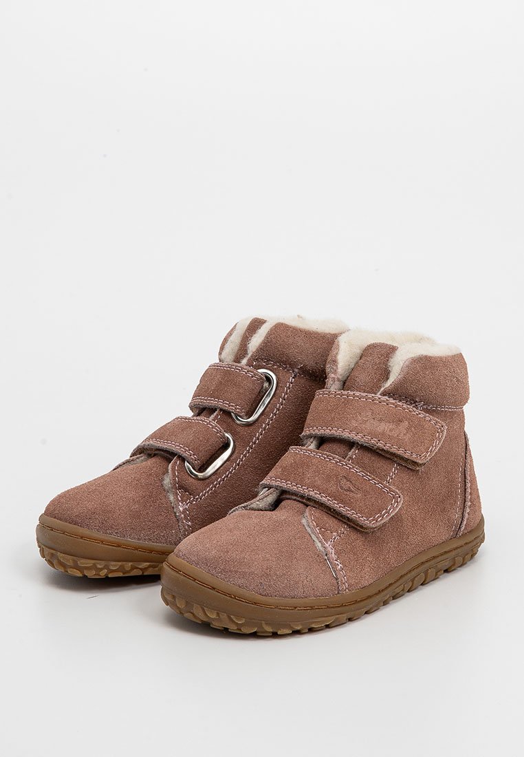 Bottines en suède marron avec deux sangles Velcro, doublure en fourrure, semelle en caoutchouc et accents beige clair. Texture épaisse, design robuste.