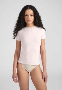 T-shirt aderente a maniche corte in tessuto rosa chiaro con scollo rotondo, texture liscia e design minimale.