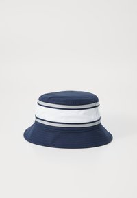 Cappello a secchiello blu navy con una fascia a righe bianche e grigie. Realizzato in tessuto, presenta una larga visiera e una parte superiore arrotondata per una vestibilità rilassata.