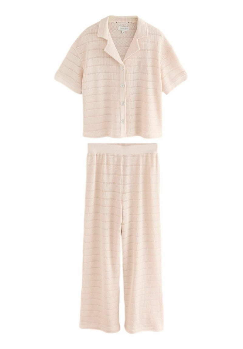 Lichtroze gebreid pyjamaset met een coller korte mouwen top met knoopsluiting en bijpassende wijde broek met een elastische tailleband.