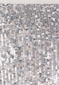 Tessuto in paillettes con una miscela di paillettes circolari argento, oro e nere disposte in file, creando una superficie riflettente e texture.