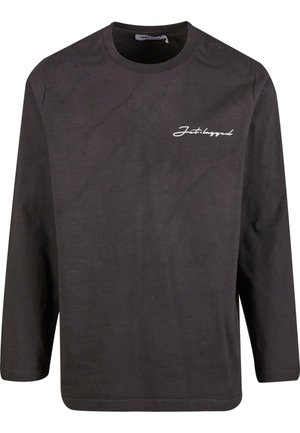 Camiseta de algodón negra de manga larga con cuello redondo y texto en cursiva blanca en el pecho. Textura suave, ajuste relajado y dobladillo recto.