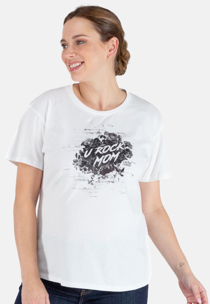 T-shirt blanc à manches courtes avec un graphique floral noir et le texte "TU DÉCHIRES, MAMAN" en lettres blanches en gras. Texture de coton lisse.