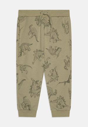 Pantaloni de trening khaki cu modele de dinozauri în imprimeu închis, având talie elastică, șnur și manșete cu nervuri.