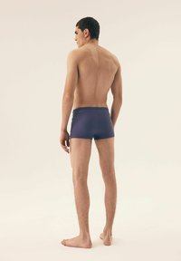 Morskie kąpielówki wykonane z elastycznej tkaniny, dopasowany krój, gładka struktura, minimalistyczny design, z średnim stanem i bez widocznych elementów metalowych.