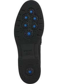 Suola di scarpa in gomma nera con fori di ventilazione circolari blu e un motivo di grip testurizzato. Logo del marchio ben visibile sul lato.