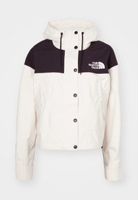 Hvit og svart hettegenser med trykknapper, glidelåslommer på sidene, og The North Face-logo på øvre høyre bryst.