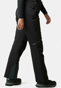 Zwarte waterdichte broek met taps toelopende pijpen, voorzien van ritszakken en versterkte onderpanelen voor duurzaamheid en bescherming.