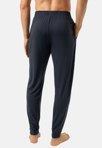 Donkerblauwe broek met elastische tailleband en zijzakken. Gemaakt van glad, lichtgewicht stof met een taps toelopend ontwerp van de pijpen.