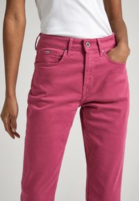 Rosa bomullshängselbyxor med rak skärning, med fickor, en frontknapp och en logotagg på midjebandet.