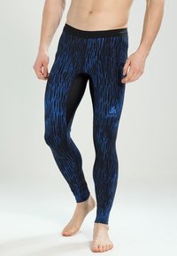 Tajta träningstights i ett svart och blått geometriskt mönster, tillverkade av stretchigt tyg, med en helt svart midja och logodetalj.