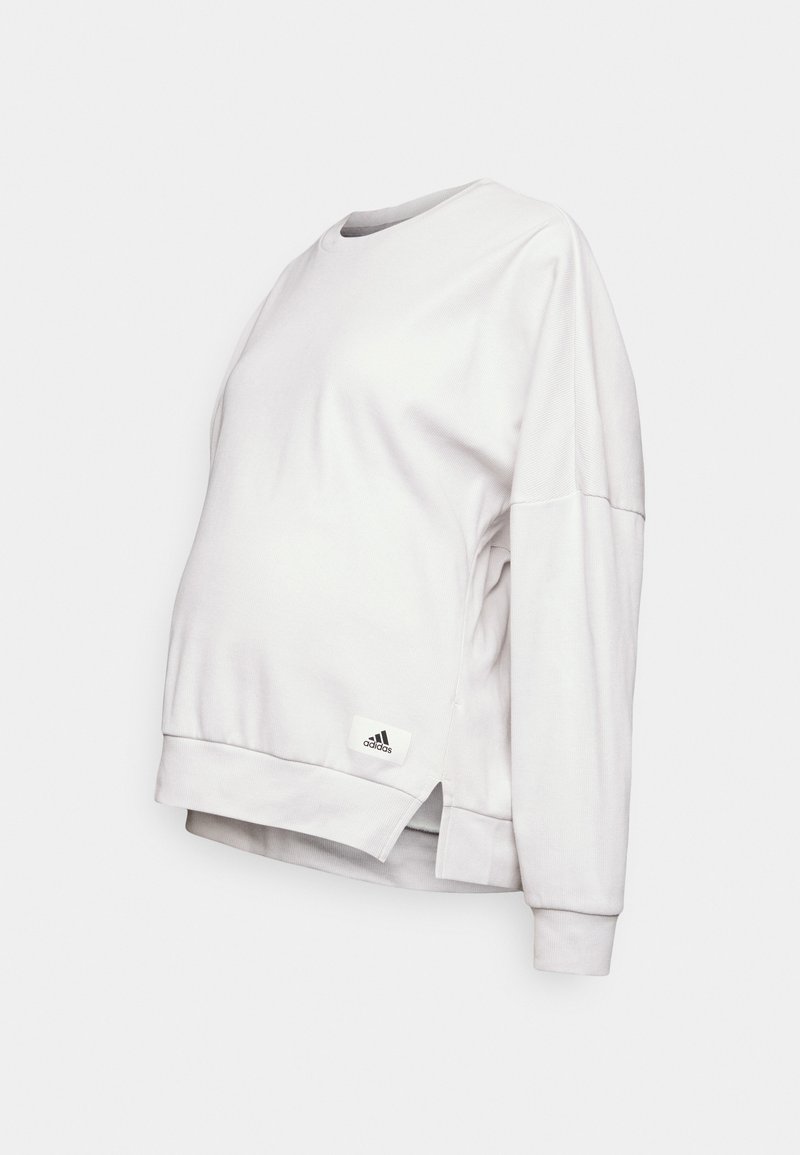 Lichtgrijze sweatshirt met lange mouwen, zijsplitten, ronde hals, gemaakt van zachte materialen, met een Adidas logo-label aan de zoom.