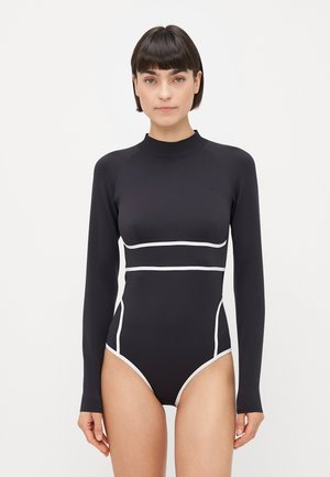 Black long-sleeve swimsuit with white accents, featuring a high neck, fitted design, and smooth texture. Cut-out side details enhance structure.