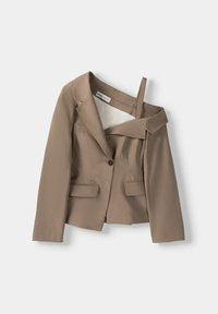 Blazer marron à côtes avec un bouton unique, deux poches avant et un élément de design décolleté. Doublure lisse à l'intérieur.