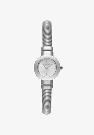 Montre-bracelet argentée pour femme Michael Kors avec cadran rond, marqueurs d'heure minimalistes et bracelet métallique flexible à nervures.
