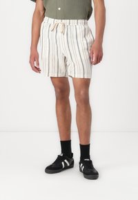 Shorts rayés beige et bleu marine pour homme avec taille élastique et cordon de serrage. Fabriqués en tissu léger, dotés de poches latérales et d'une coupe décontractée.