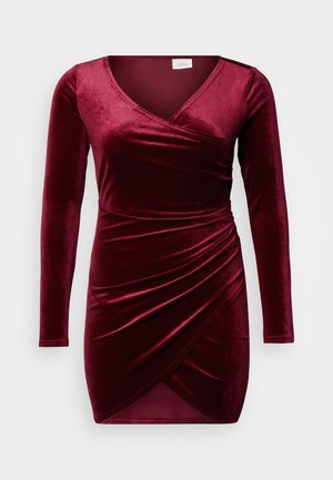 Obleka iz bordo žameta z dolgimi rokavi, z nagubanjem v pasu in globokim v-izrezom za oprijeto silhueto.