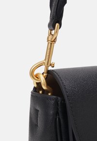 Black leather handbag with a textured surface, featuring a gold metal clasp and strap hardware, accentuating its modern design.
