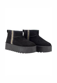 Botines de ante negro con suela de plataforma gruesa negra. Presentan costuras decorativas en dorado y plateado a lo largo del lateral.