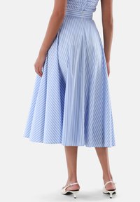 Hellblau gestreiftes Kleid mit einem vollen, ausgestellten Rock. Der Stoff wirkt glatt und leicht, mit dünnen vertikalen weißen Streifen.