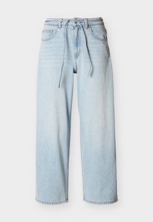 Lichtblauwe denim spijkerbroek met wijde pijpen, een taille met trekkoord, voorzakken en riemlussen tegen een effen achtergrond.