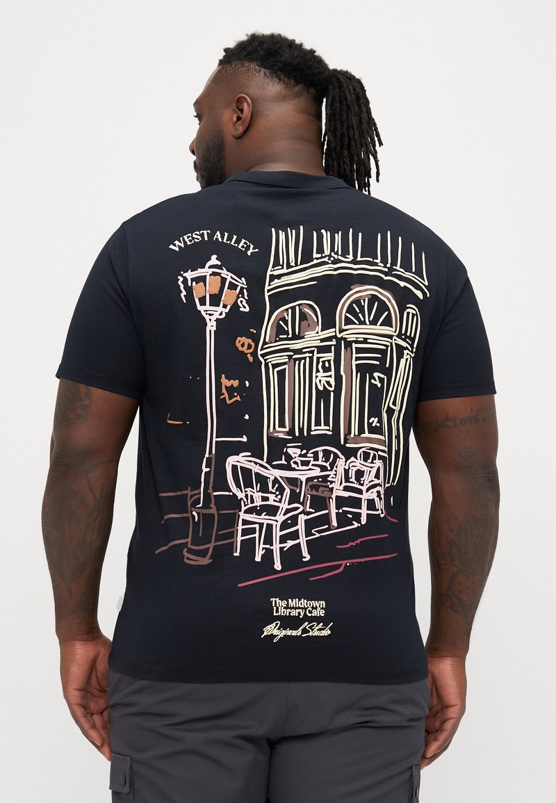 Tricou din bumbac negru cu un grafic care ilustrează o scenă de cafenea cu un felinar, scaune și o clădire. "West Alley" este imprimat deasupra desenului.