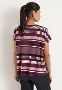 Kortærmet, maroon top med horisontale striber i pink, hvid og sort; letvægtsstof med en afslappet pasform og sideslids.