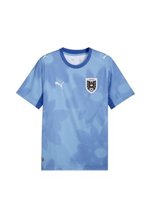 Jasnoniebieska koszulka piłkarska z krótkim rękawem z herbem drużyny Austrii, logo Puma, niebieskim kołnierzykiem i subtelnym kwiatowym wzorem z przodu.