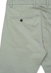 Light green trousers made of a smooth fabric, featuring two back pockets with a single black button on one side and subtle stitching details.